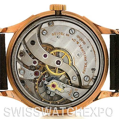 This image shows the case back removed, revealing the internal mechanical movement of a vintage Patek Philippe watch.