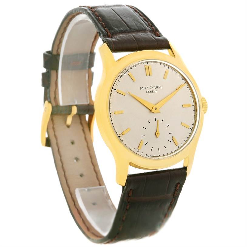 The Vintage Patek Philippe watch is shown at a three-quarter angle, highlighting its round dial, gold case, and leather strap.
