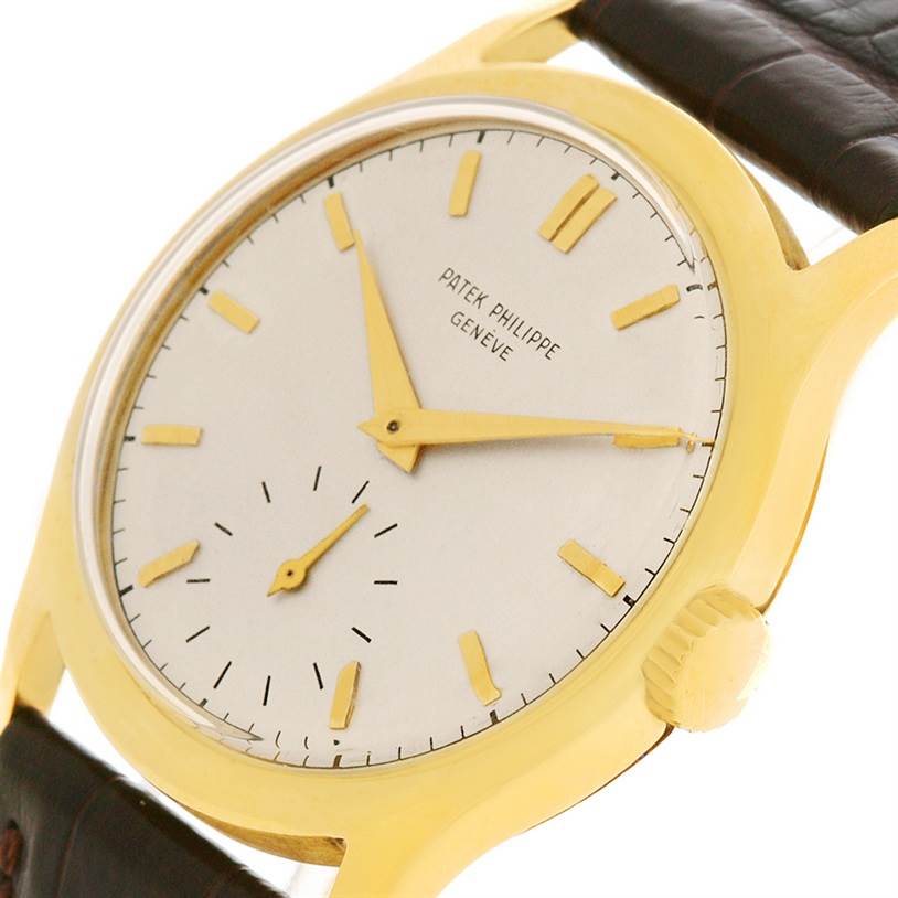 This image shows a close-up, angled view of a Vintage Patek Philippe watch, highlighting its dial, golden hands, hour markers, and crown.