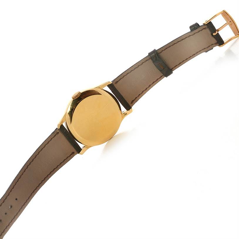 The image shows the back view of a Vintage Patek Philippe watch, highlighting the case, crown, and leather strap.