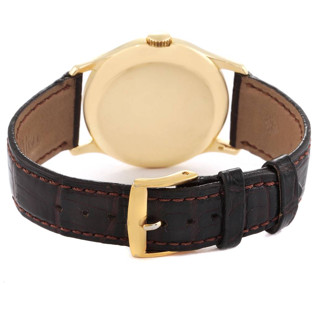 This image shows the back and clasp of a Vintage Patek Philippe watch, featuring a gold case and black leather strap.