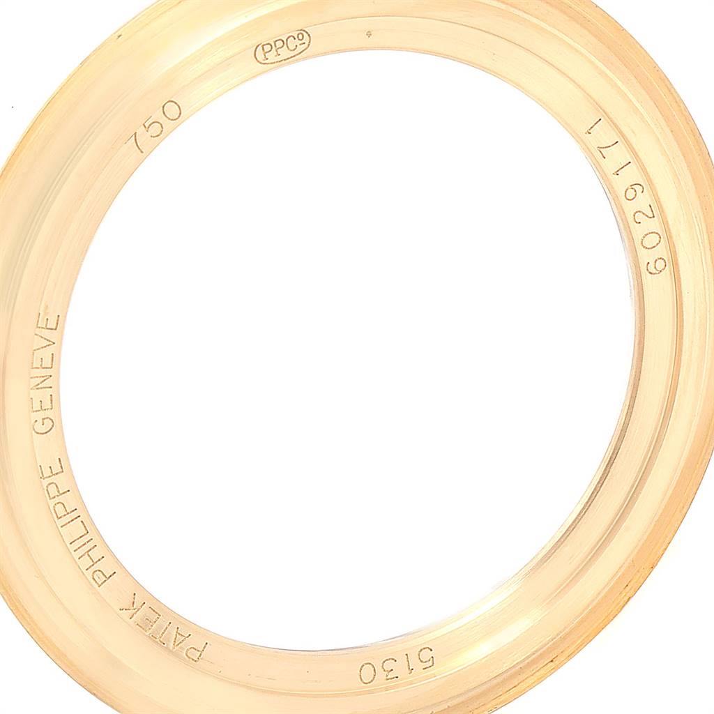 The image shows a close-up of the bezel for a Patek Philippe Complications 5130J Men's Yellow Gold Silver Dial 5130J Men's Yellow Gold Silver Dial model watch, with inscriptions and serial numbers visible.