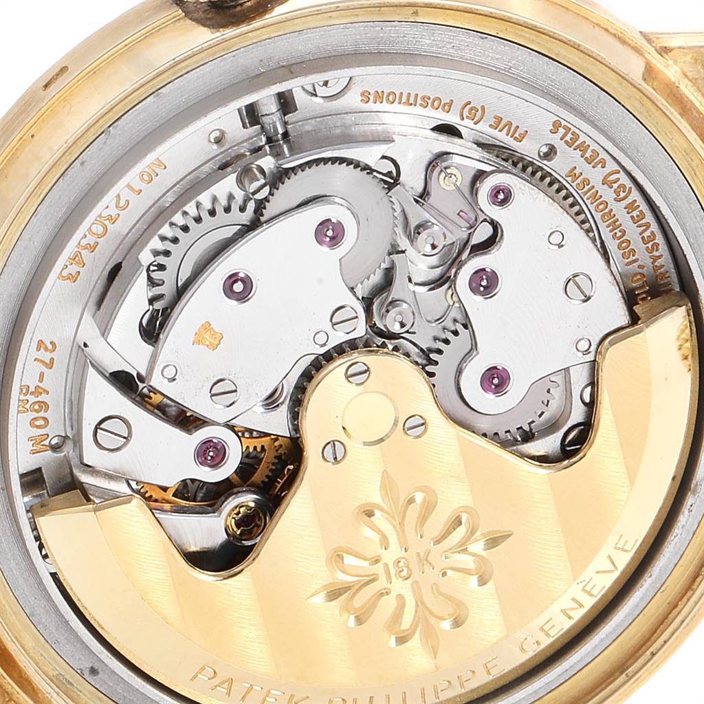 This image shows the intricate inner mechanical movement of a Vintage Patek Philippe watch, specifically highlighting gears and engravings.