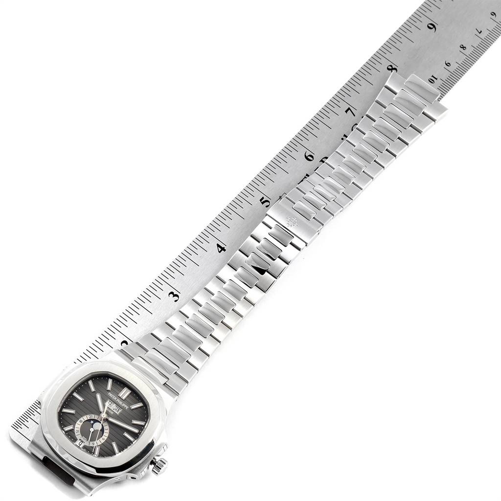 The image shows the Patek Philippe Nautilus 5726/1A-001 Men's Stainless Steel Black Dial 5726/1A-001 Men's Stainless Steel Black Dial watch laid flat with its bracelet extended next to a ruler.