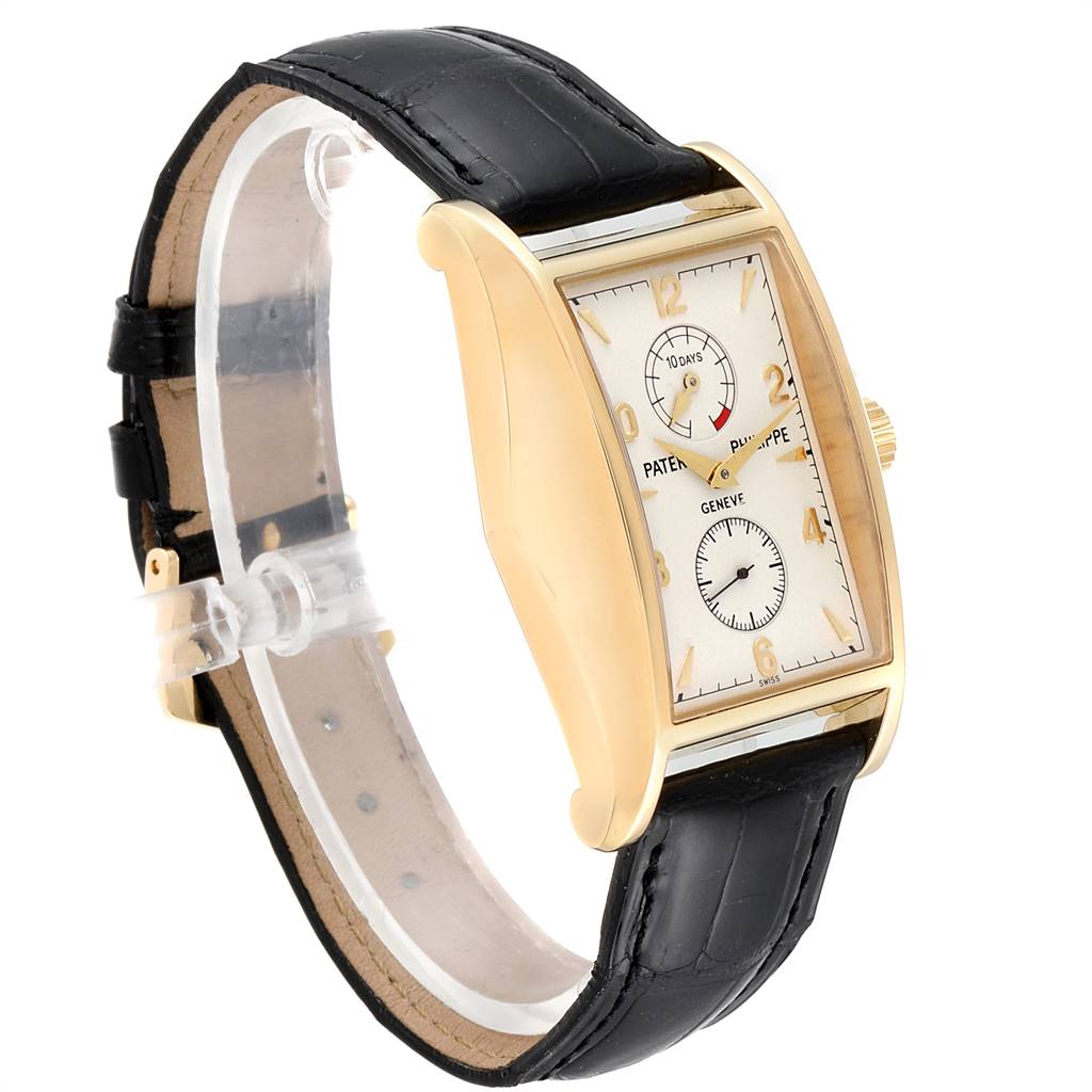 The image shows a side angle of the Patek Philippe Gondolo 5100J Men's Yellow Gold Silver Dial 5100J Men's Yellow Gold Silver Dial watch, highlighting its gold case, white dial, and black leather strap.