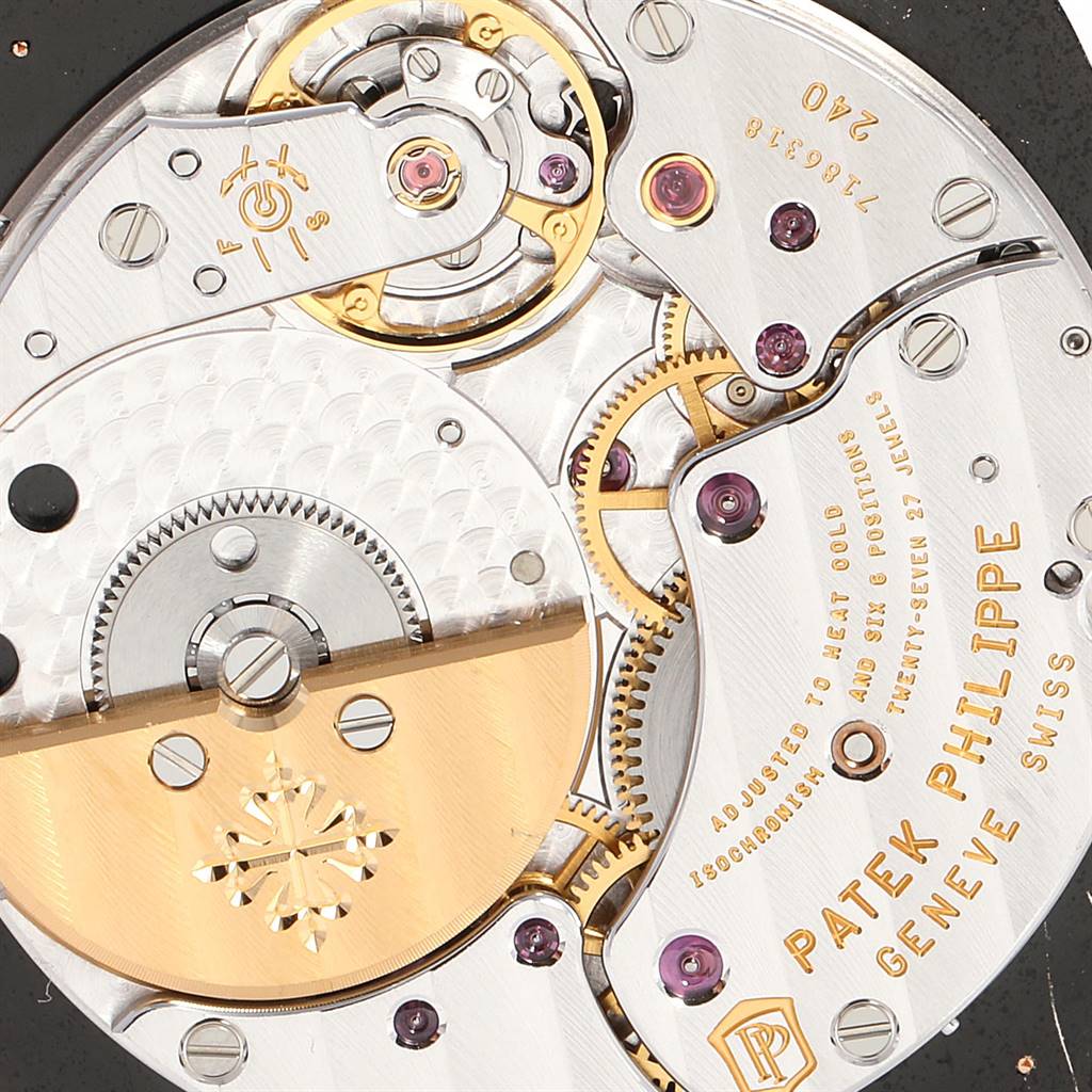 This image shows the intricate movement mechanism of a Patek Philippe Golden Ellipse 5738R Men's Rose Gold Black Dial 5738R Men's Rose Gold Black Dial watch, showcasing gears and the brand's engravings.