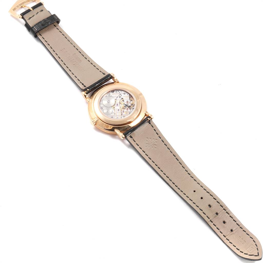 The image shows the back view of a Patek Philippe Calatrava 5119R Men's Rose Gold White Dial 5119R Men's Rose Gold White Dial watch, highlighting the inner mechanism and leather straps.