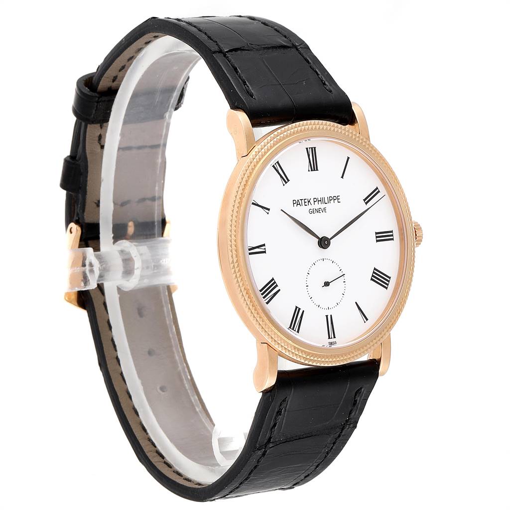 The image shows a Patek Philippe Calatrava 5119R Men's Rose Gold White Dial 5119R Men's Rose Gold White Dial watch from a 3/4 side angle, highlighting its black leather strap and white dial with Roman numerals.