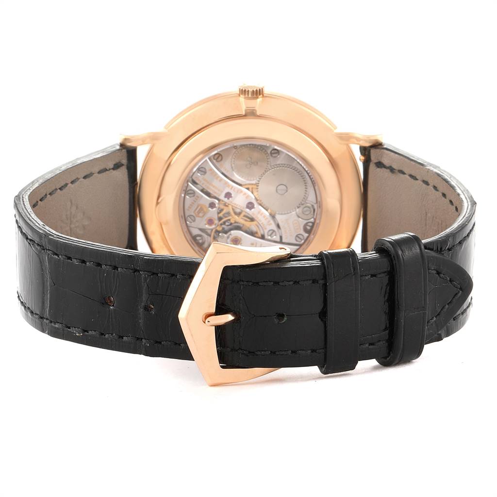 The image shows the back view of a Patek Philippe Calatrava 5119R Men's Rose Gold White Dial 5119R Men's Rose Gold White Dial watch, highlighting its transparent case back and black leather strap.