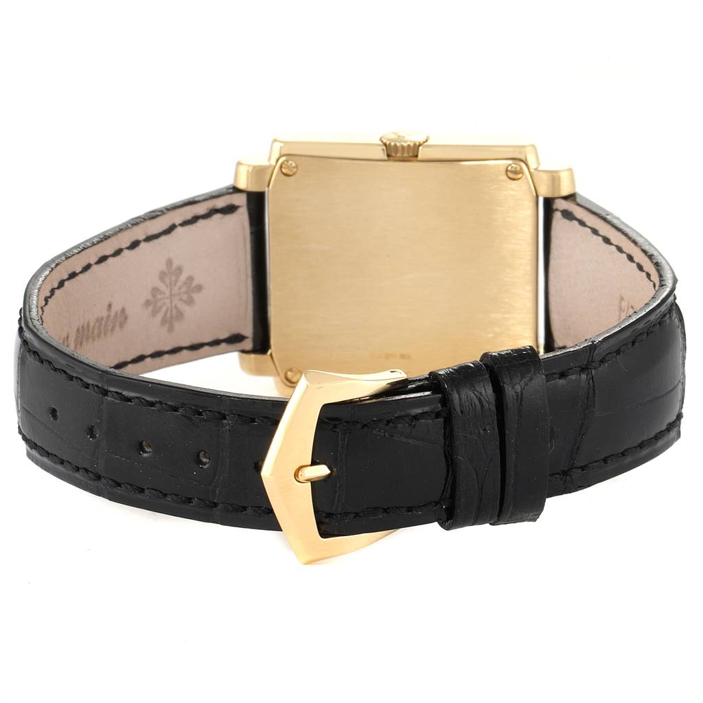 The image shows the back and strap of a Patek Philippe Gondolo 5024J Men's Yellow Gold White Dial 5024J Men's Yellow Gold White Dial watch, featuring a gold case and a black leather strap with a gold buckle.