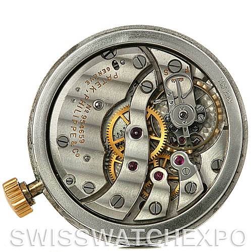 The image shows the movement mechanism of a vintage Patek Philippe watch from a top-down angle, highlighting the gears and inner workings.