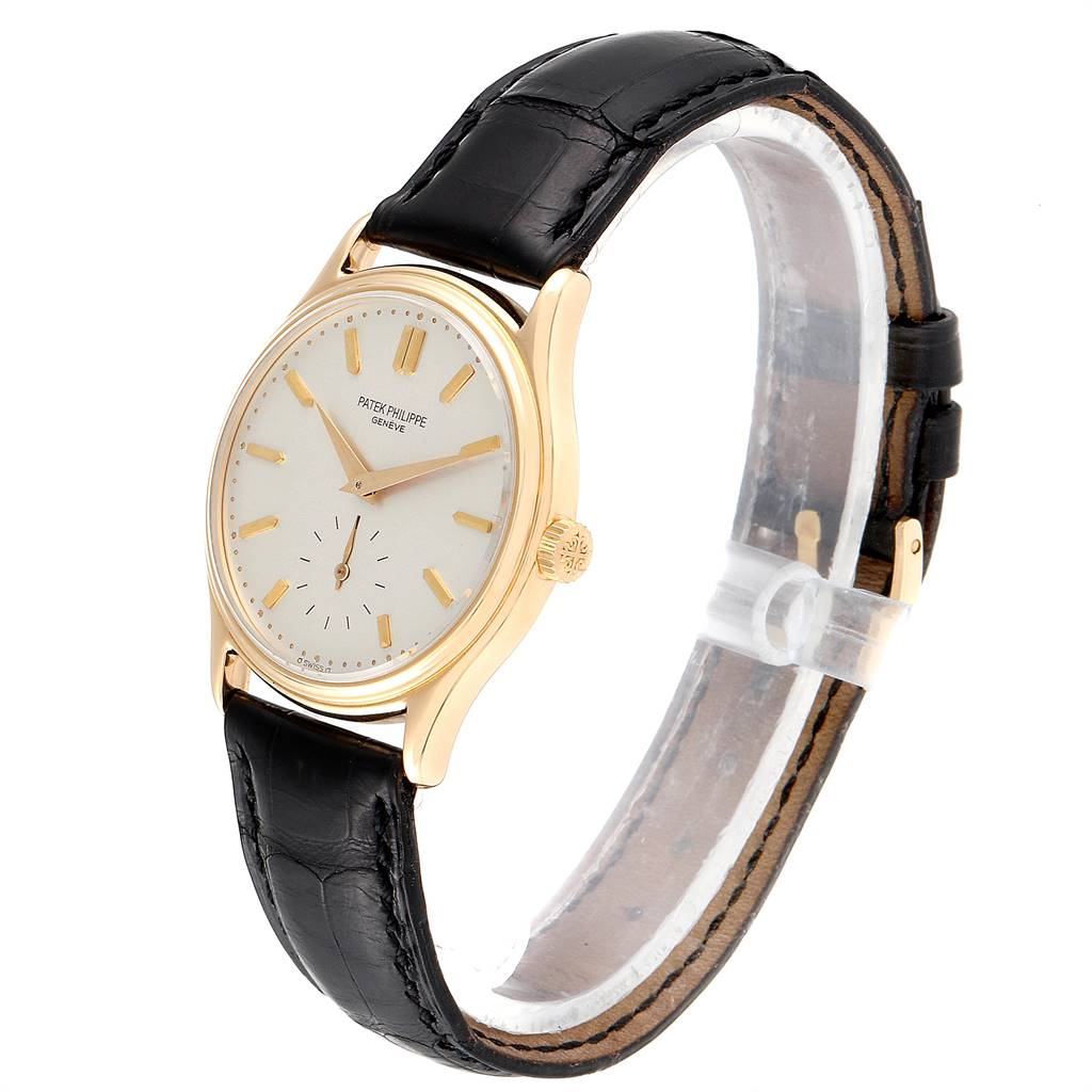 The image shows a Patek Philippe Calatrava 3923 Men
s Yellow Gold Silver Dial 3923 Men
s Yellow Gold Silver Dial watch from a side angle, displaying its face, bezel, and leather strap.