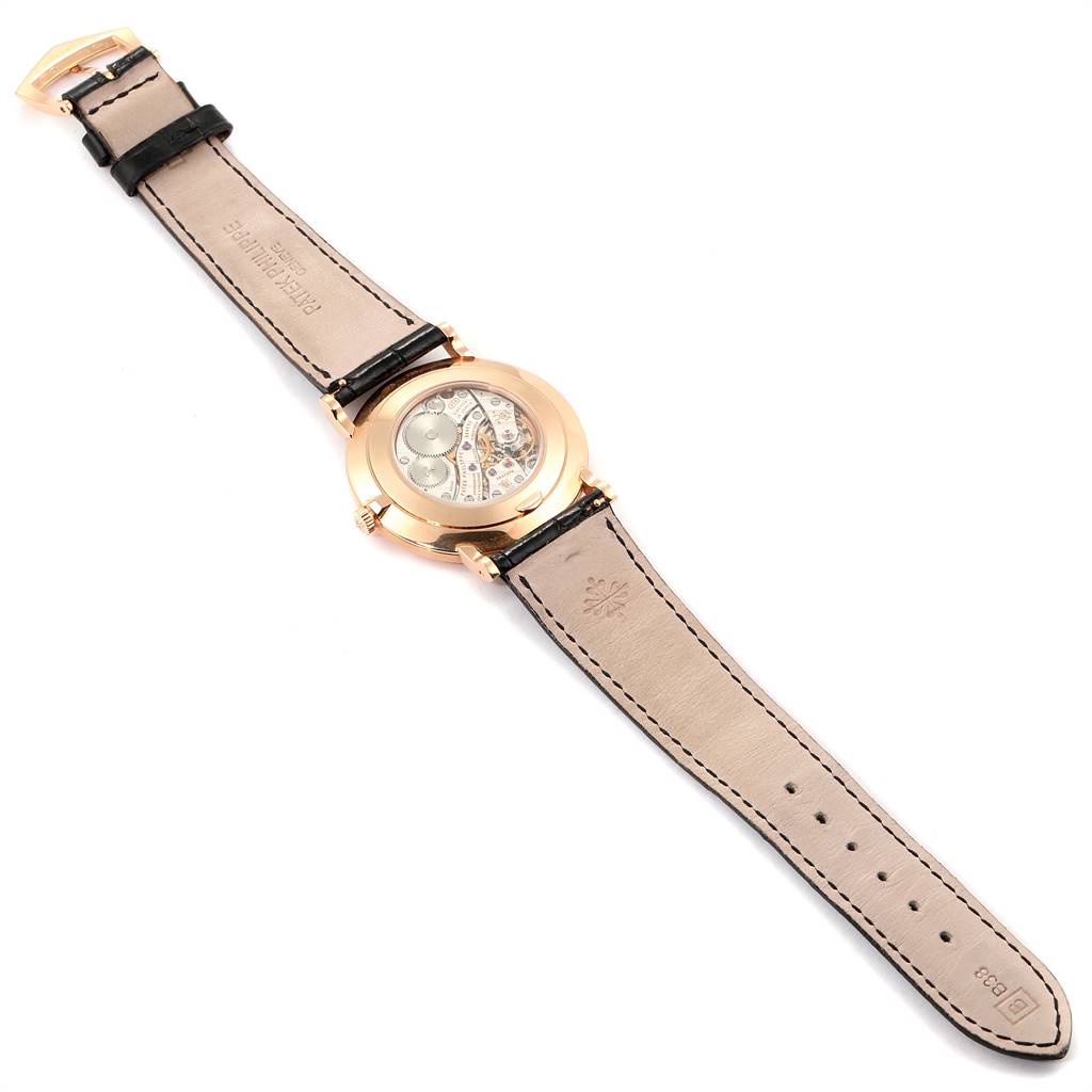 The image shows a Patek Philippe Calatrava 5119R Men's Rose Gold White Dial 5119R Men's Rose Gold White Dial watch from the back, highlighting the transparent case back and leather strap.