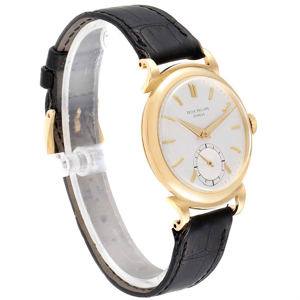 The image shows a side angle of the Patek Philippe Vintage watch, highlighting its gold case, white dial, and black leather strap.