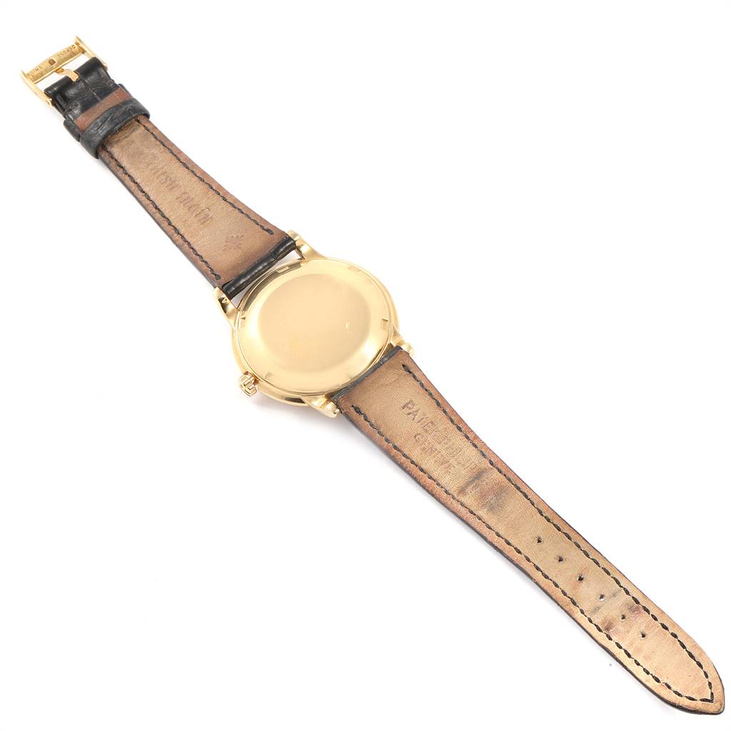 The image shows the back of a Vintage Patek Philippe watch, displaying the case back, leather straps, and buckle.