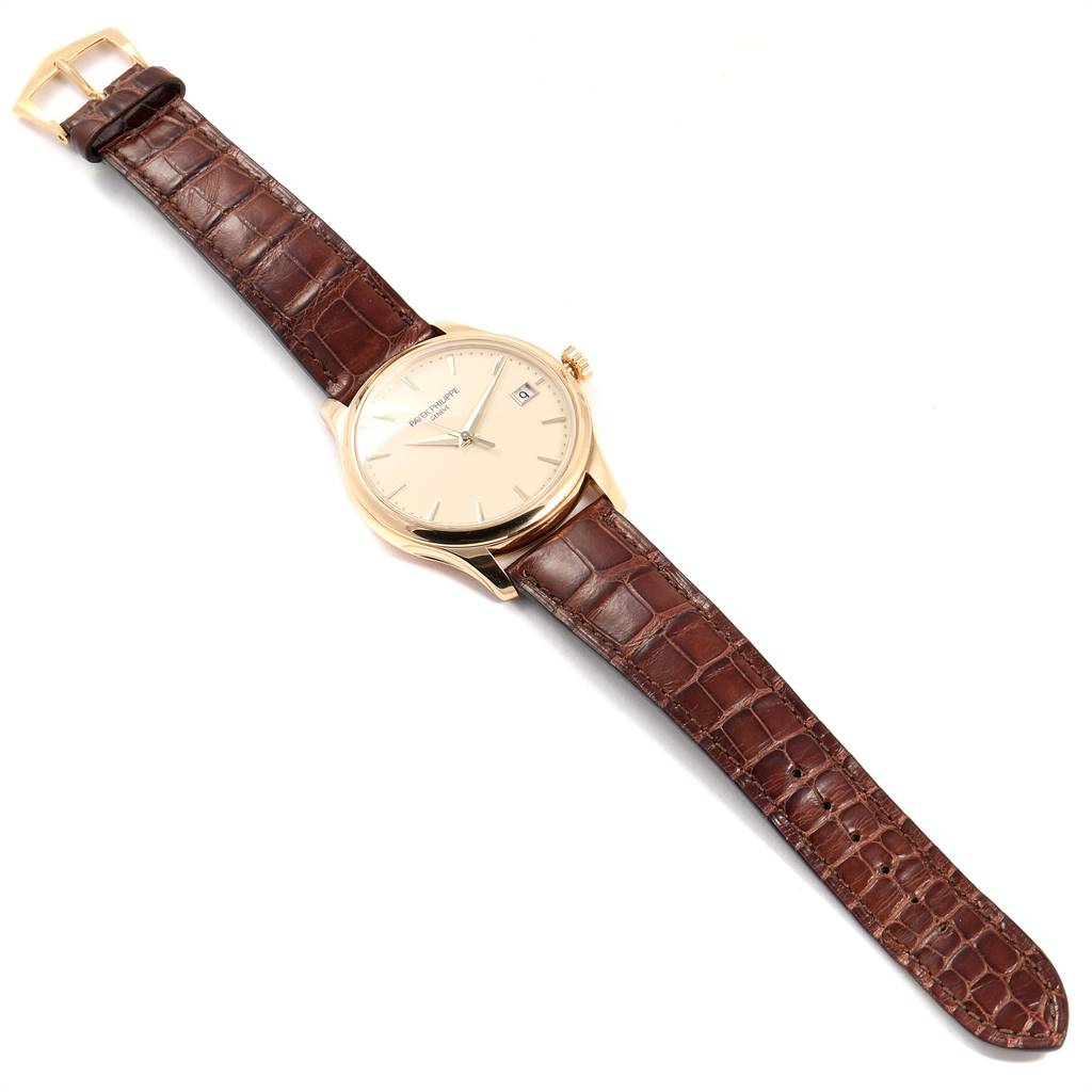 The image shows a top-down view of a Patek Philippe Calatrava 5227 Men's Yellow Gold Beige Dial 5227 Men's Yellow Gold Beige Dial watch, displaying the full face, strap, and buckle.