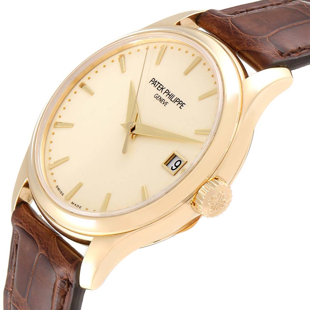 The image shows a Patek Philippe Calatrava 5227 Men's Yellow Gold Beige Dial 5227 Men's Yellow Gold Beige Dial watch at a slight angle, highlighting the face, crown, and leather strap.