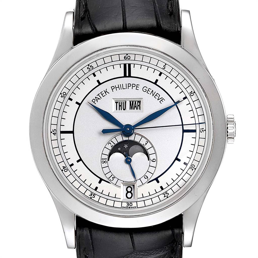 The Complications model by Patek Philippe is shown from a front angle, displaying its dial, date, moon phase, and a portion of the leather strap.