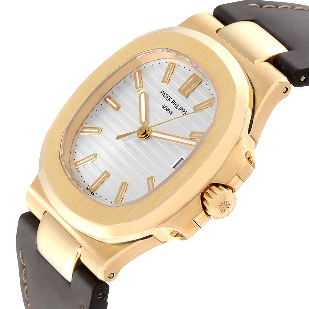 The image shows a Patek Philippe Nautilus 5711J Men's Yellow Gold Silver Dial 5711J Men's Yellow Gold Silver Dial watch at a three-quarter angle, highlighting the dial, case, crown, and part of the strap.