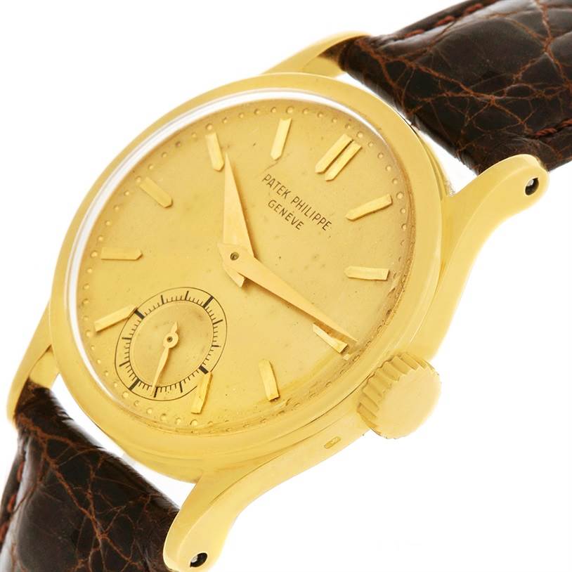 This image shows a side angle of a vintage Patek Philippe watch, highlighting its gold case, crown, and leather strap.