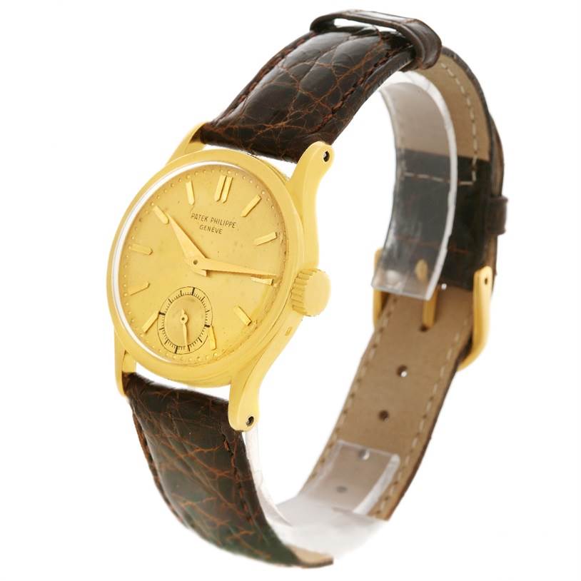 This image shows a side-angle view of the Vintage Patek Philippe watch with a gold case and brown leather strap.