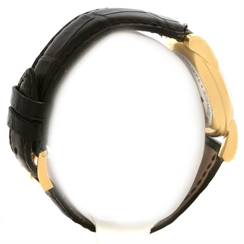 Side view of a Patek Philippe Vintage model watch showing the leather strap and the gold case.