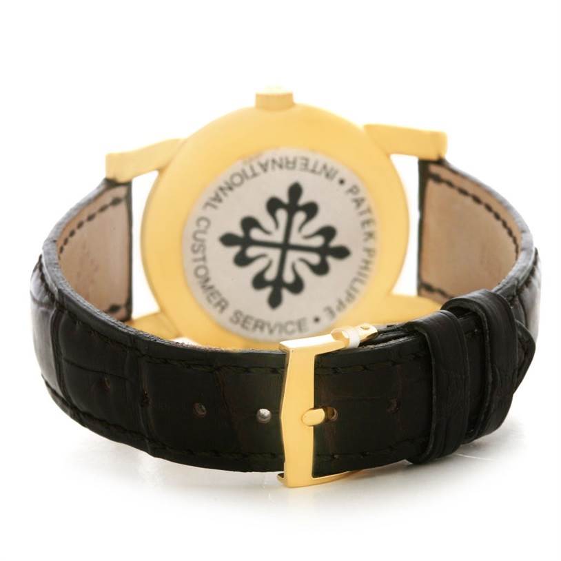 The image shows the rear view of a Vintage Patek Philippe watch, focusing on the leather strap and gold buckle.