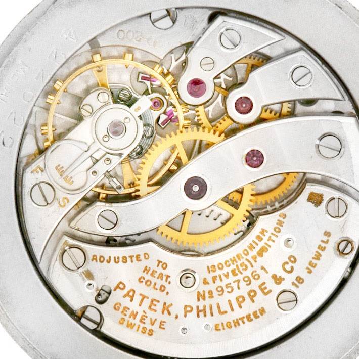 The image shows the internal mechanical movement of the Vintage Patek Philippe watch, highlighting gears and engraved details.