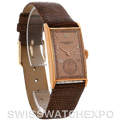 The image shows a side angle of a vintage Patek Philippe watch, highlighting its rectangular face, brown leather strap, and gold-tone case.
