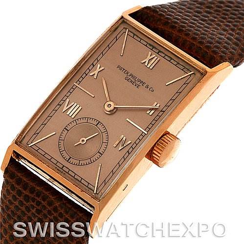This image shows a Patek Philippe Vintage 1468 Men's Rose Gold Pink Dial 1468 Men's Rose Gold Pink Dial watch at an angled view, highlighting the rectangular dial, crown, and leather strap.