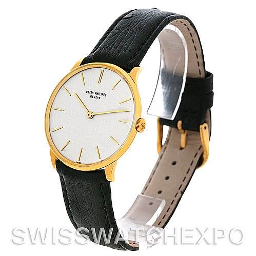 The image shows a side-angle view of a Vintage Patek Philippe watch, highlighting its black leather strap, gold case, and white dial.