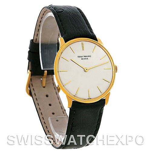 The image shows a Patek Philippe Vintage model watch with a gold case, white dial, and black leather strap, angled slightly to the right.