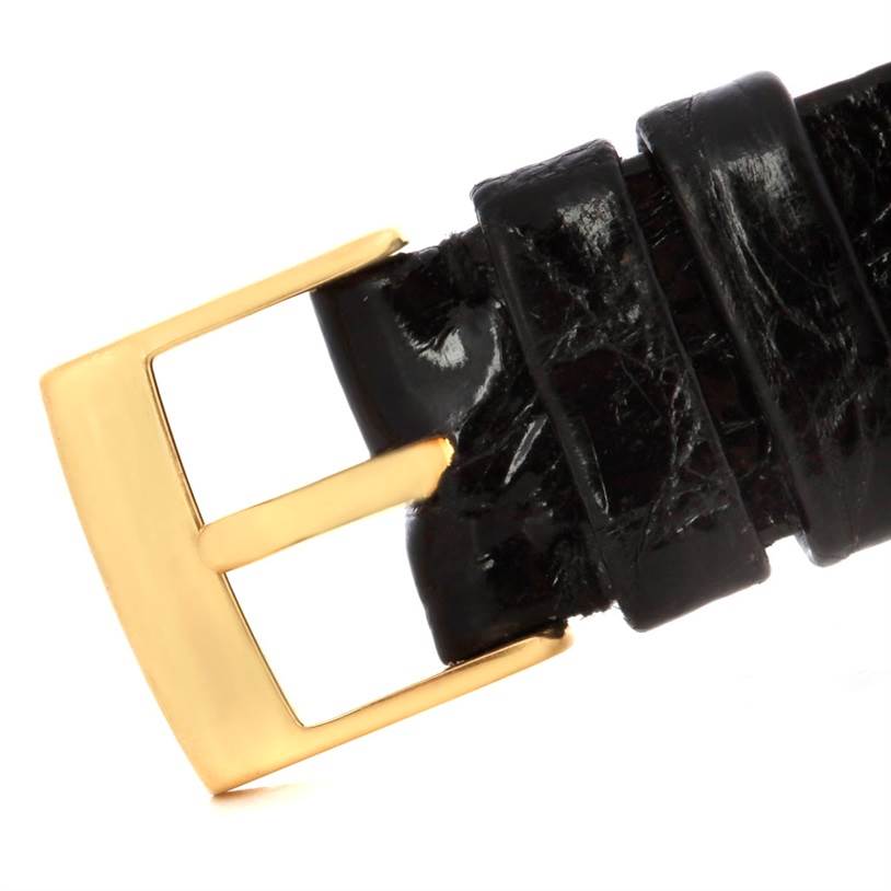 This image shows a close-up of a black leather strap and a gold buckle of a Vintage Patek Philippe watch.