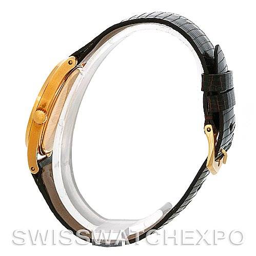 This image shows a side view of a Vintage Patek Philippe watch, highlighting the gold case, crown, and black leather strap with a buckle.