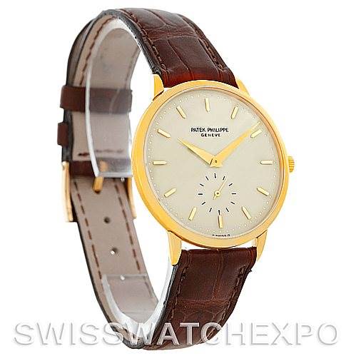 The image shows a side angle of a Vintage Patek Philippe watch featuring a brown leather strap and a gold case with a beige dial.