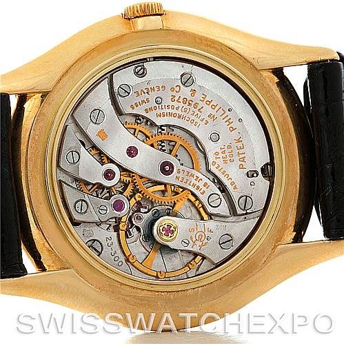 The image shows the back view of a Vintage Patek Philippe watch, displaying its intricate movement and internal mechanical components.