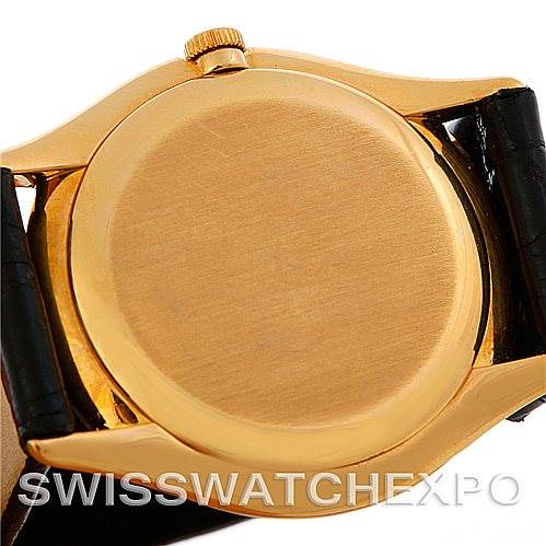 This image shows the case back and crown of a Vintage Patek Philippe watch with a leather strap from a rear angle.