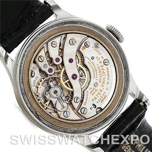 The image shows the back view of a Vintage Patek Philippe watch, revealing its intricate mechanical movement and components.