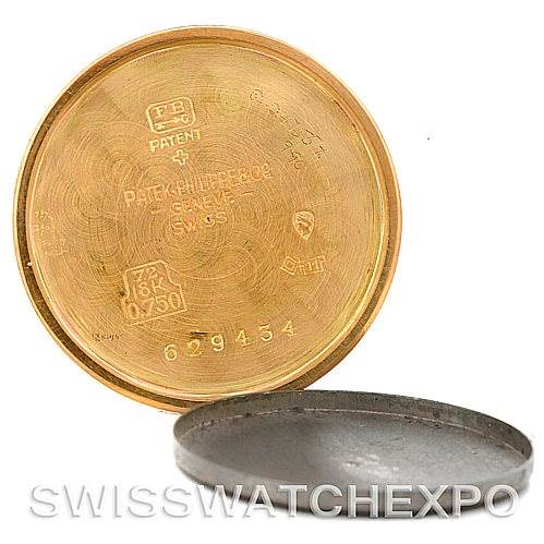 The image shows the open case back covers of a Vintage Patek Philippe watch, displaying internal engravings and serial numbers.