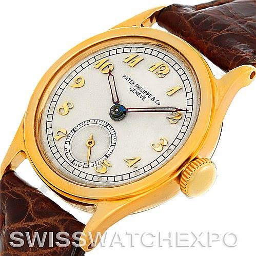 This image shows an angled close-up of a Vintage Patek Philippe watch face and brown leather strap.