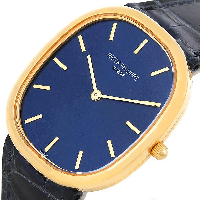The Patek Philippe Golden Ellipse 3738 Men's Yellow Gold Blue Dial 3738 Men's Yellow Gold Blue Dial watch is shown at a slight angle, highlighting its blue dial, gold case, and part of the black strap.