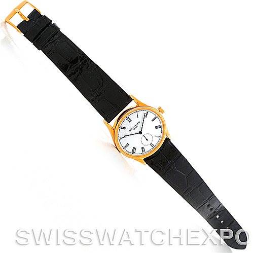 The image shows a top view of a Patek Philippe Calatrava 3796 Men's Yellow Gold White Dial 3796 Men's Yellow Gold White Dial watch with a black leather strap and gold bezel.