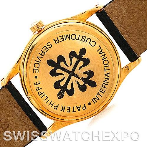 The image shows the back of the Patek Philippe Calatrava 3796 Men's Yellow Gold White Dial 3796 Men's Yellow Gold White Dial watch with a gold case, leather straps, and engraved logo and text.