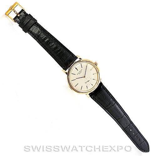 This is a top-down view of a Vintage Patek Philippe watch, showing its leather strap, gold case, and dial.