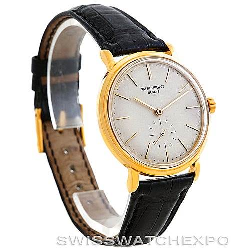 This image shows a three-quarter side view of a Vintage Patek Philippe watch, highlighting the face, bezel, crown, and black leather strap.