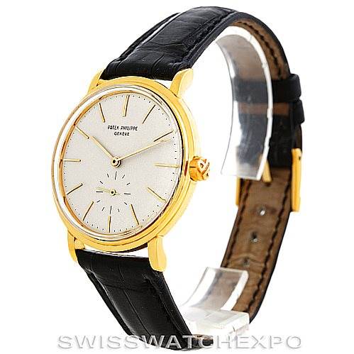 The image shows a side angle of a Vintage Patek Philippe watch, highlighting its gold case, black leather strap, and white dial.