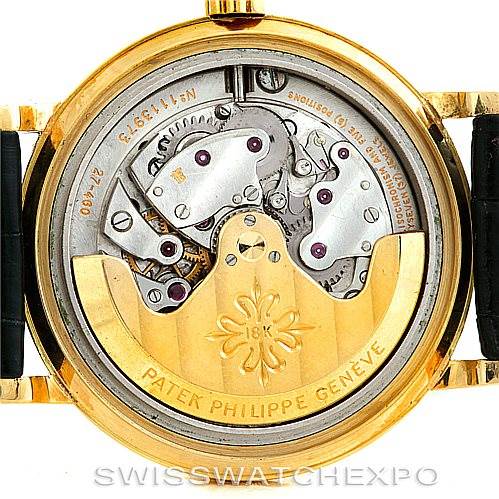 The image shows the back view of a Vintage Patek Philippe watch, revealing its intricate movement and inner components.