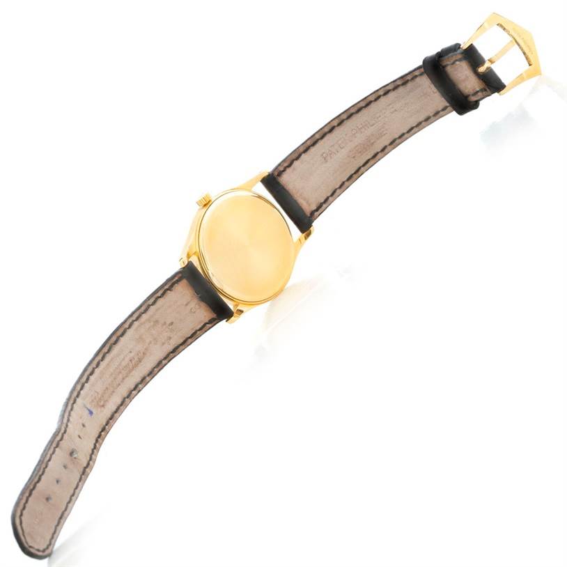 The image shows the back view of a Patek Philippe Calatrava 3796 Men's Yellow Gold Silver Dial 3796 Men's Yellow Gold Silver Dial watch with its leather strap and buckle visible.