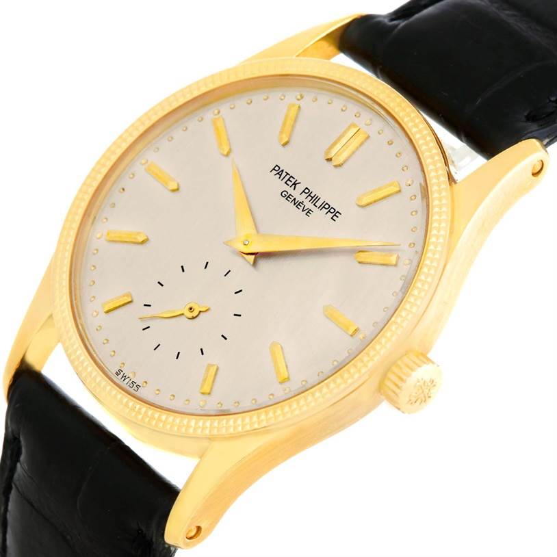 The image shows a Patek Philippe Calatrava 3796 Men's Yellow Gold Silver Dial 3796 Men's Yellow Gold Silver Dial watch at an angle highlighting its face, crown, and part of the leather strap.