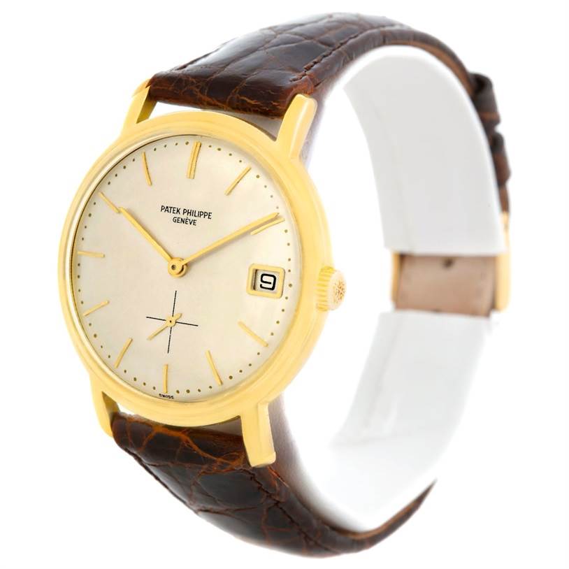 The image shows a Vintage Patek Philippe watch at a slight angle, highlighting its gold case, cream dial, date window, and brown leather strap.
